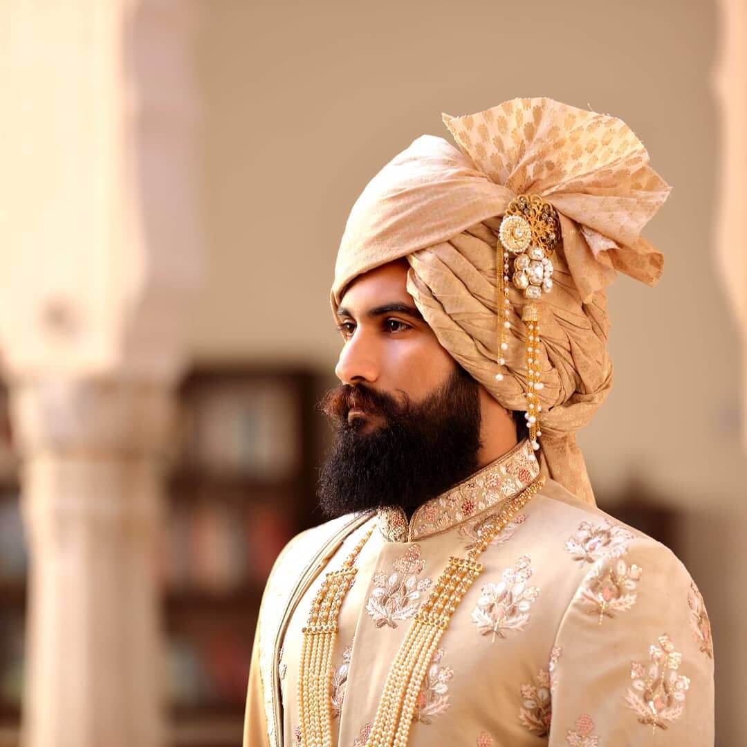 Indian prince with a short full beard with a skin fade as a haircut. He  also has diamond studs as earrings on Craiyon